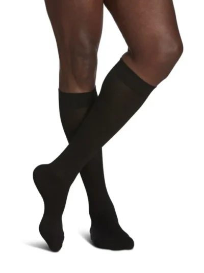 Man wearing Sea Island Cotton compression socks with crossed legs in black color